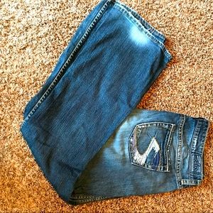 Women’s silver jeans with flare bottom and blue S on pockets.